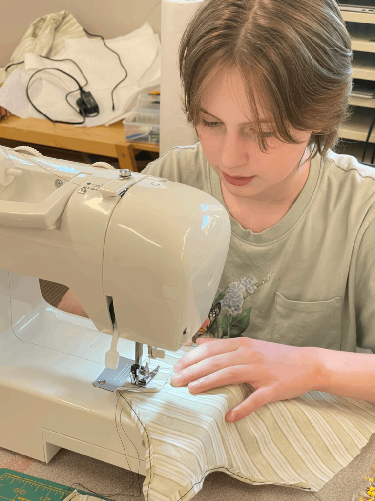 A middle school student using a sewing machine