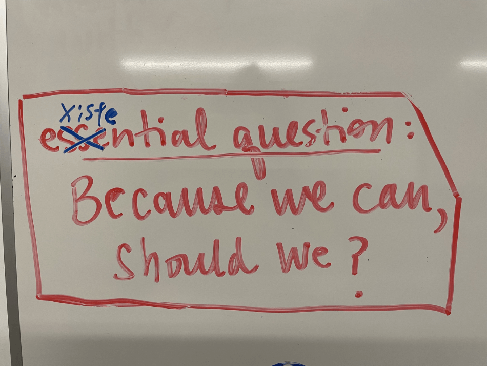 Photo of a whiteboard that says, 'essential question: because we can, should we?' Part of 'essential' is crossed out and changed to 'existential'