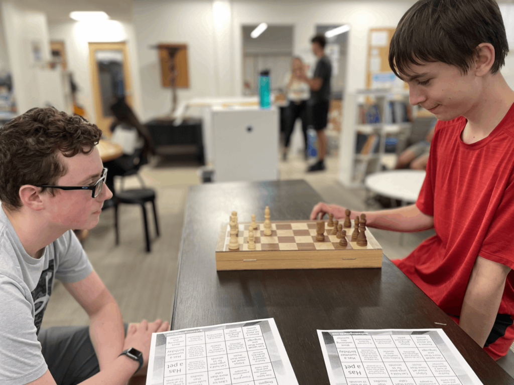 Photo of two male students on campus engaged in a game of chess